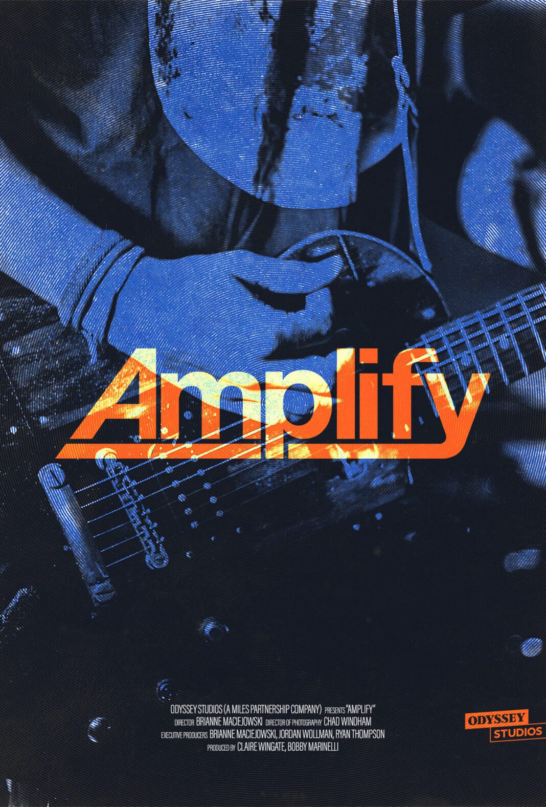 A close-up of a person playing an electric guitar, with the word "Amplify" in bold orange and yellow letters over the image. The background is a blue-toned photograph.